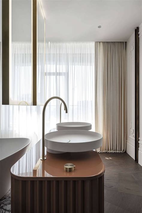 A Bathroom With Two Sinks And A Large Mirror In The Wall Above It That