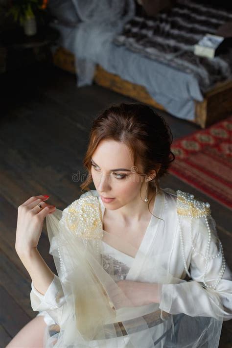 A Large Portrait Of A European Looking Brunette Bride Sits On A Chair