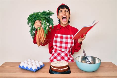Bella Brunette Mujer Cocinando Pastel De Zanahoria Leyendo Recetas Libro Enfadado Y Enfadado