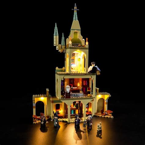 A Lego Lit Up Castle With People Standing In Front Of It And The Lights On