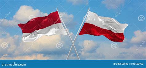 Two Crossed Flags Indonesia And Poland Waving In Wind At Cloudy Sky