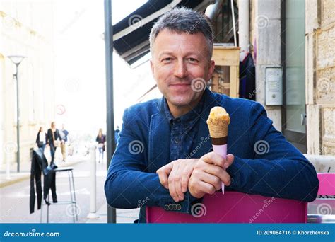 handsome man eating ice cream  street cafe stock photo image