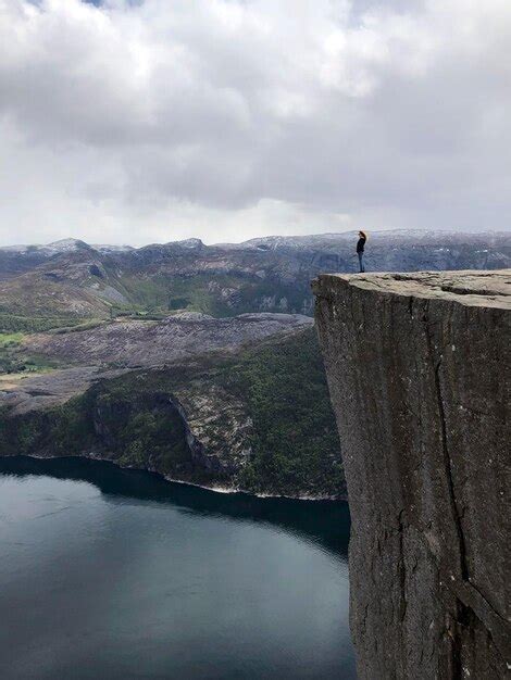 Una niña parada en preikestolen o pulpit rock mirando lysefjord o