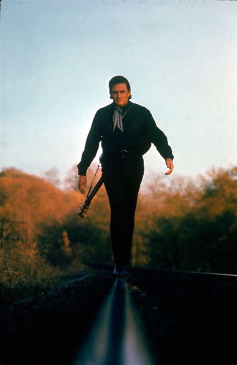 Johnny Cash Walking Along The Line Of A Railway Track With His Guitar