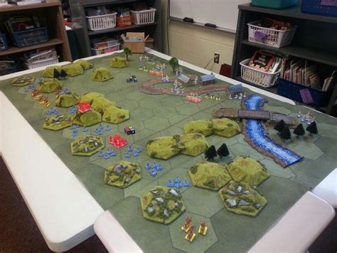 a table that has some small game pieces on it and is covered in green paper