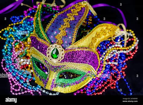 Top Down View Of A Colorful Jester Mask On A Bed Of Beads Black