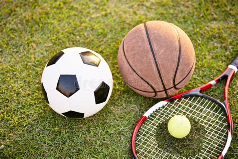 Football Basketball and Tennis Ball and Racket on Grass Stock Image ...