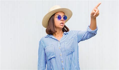 Mujer latina que se siente conmocionada y sorprendida señalando y