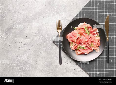 Plate With Slices Of Delicious Ham And Cutlery On Grunge Background