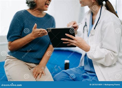 Doctor And Senior Female Patient Who Lie On The Bed While Checking