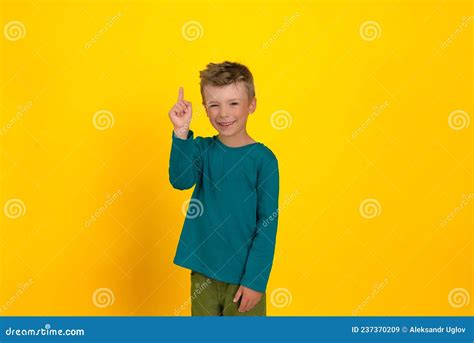 A Six Year Old Boy Smiles And Shows With A Hand Gesture That He Has An