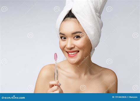 Beautiful Young Woman On White Isolated Background Holds A Toothbrush