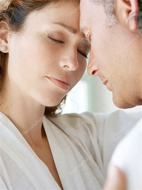 Close Up Of A Mature Couple Hugging At Home With Their Foreheads