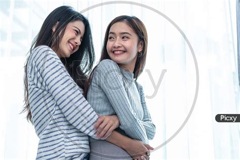 Image Of Two Asian Lesbian Women Hug And Embracing Together In Bedroom