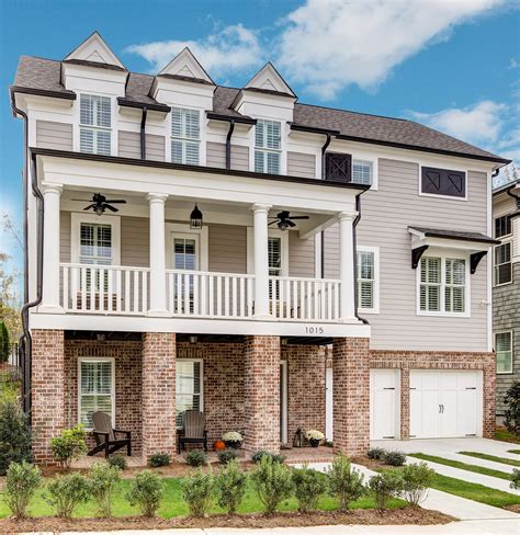 Three story home with brick and siding. Large dormers and beautiful