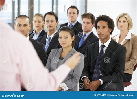 Group Of Business People Listening To Speaker Giving Presentation Stock