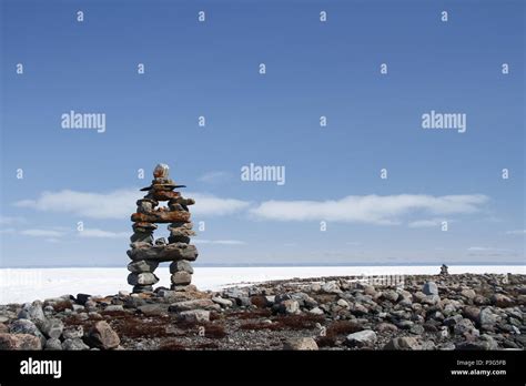 Inukshuk or Inuksuk landmark with frozen bay in the background near Arviat, Nunavut Stock Photo ...