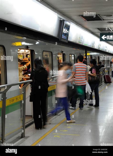 Passengers Board And Alight From A Shanghai Metro Line 2 Train At A