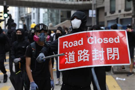 Hong Kong plunged into commuter chaos as protesters block roads and target rail services – with ...