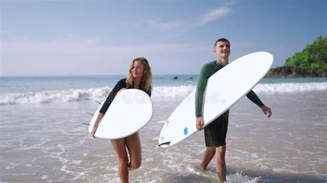 Happy Surfers Couple In Love Coming Out Of Ocean Waves Satisfied With