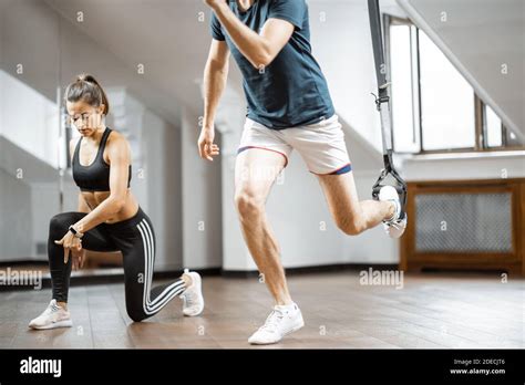 Female Trainer And Man Practising Trx At Gym Suspension Training That