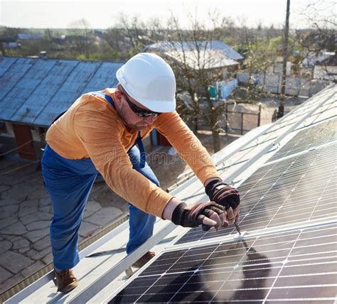 Installing Solar Photovoltaic Panel System On Roof Of House Stock Photo