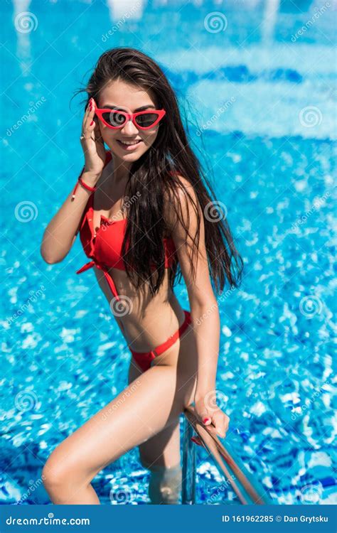 Elegant Woman In The White Bikini On The Sun Tanned Slim And Shapely