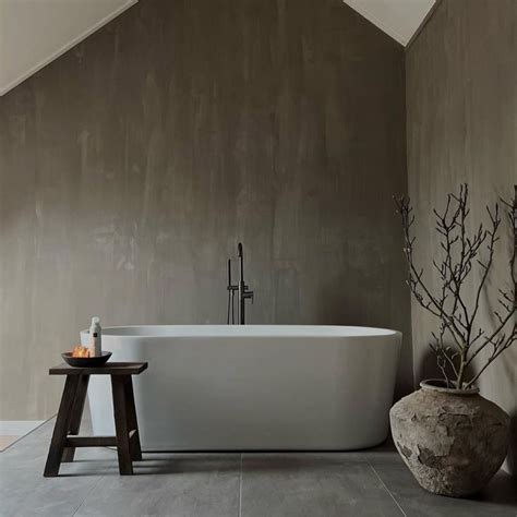 A Large White Bath Tub Sitting Next To A Wooden Stool In A Room With