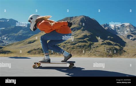 Cinematic downhill longboard session. Young woman skateboarding and ...