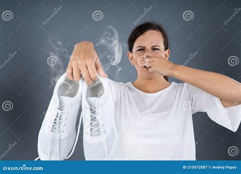 Woman Holding Stinky Shoes stock image. Image of footwear - 210572087