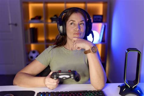Beautiful Brunette Woman Playing Video Games Wearing Headphones Looking Confident At The Camera