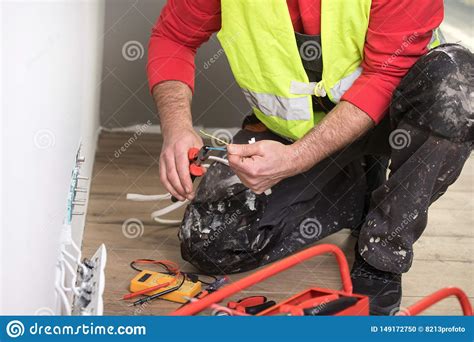 Manos De Un Electricista Del Electricista En El Trabajo De La Manitas