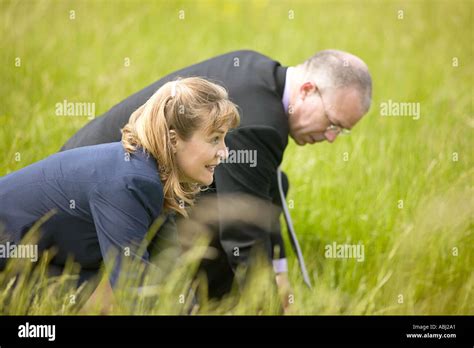 Business Man And Woman Line Up To Compete In Race On Grass Track Stock