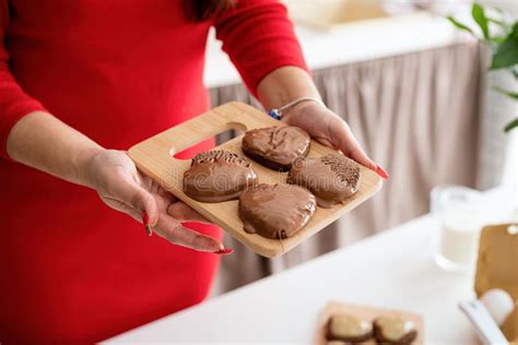 Woman In Red Dress Making Valentine Cookies At The Kitchen Stock Photo