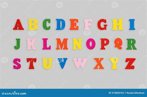 Wooden Letters Of The English Alphabet Multi Colored On A Grey