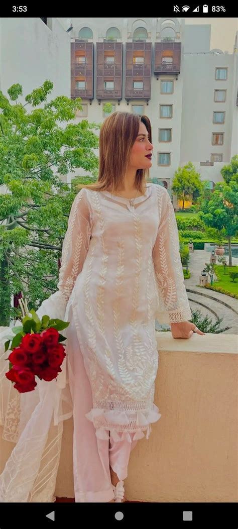 A Woman Standing On Top Of A Building Next To A Red Rose Bouquet In Her