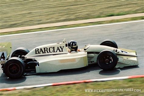 A Man Driving A Race Car On A Track