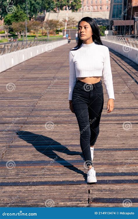 Hermosa Mujer Latina De Cabello Negro Caminando Sobre Un Puente Con Piso De Madera Foto De