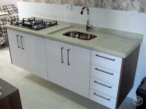 A Kitchen Counter With Two Sinks And A Stove Top In The Middle Next To