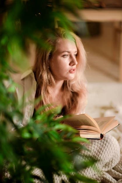 Premium Photo Young Woman Reading A Book While Sitting On Her Bed At