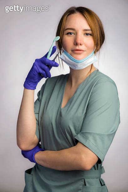 Portrait Of Attractive Female Dentist With Work Tools Wearing Uniform