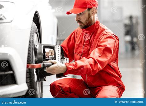 Auto Mechanics Making Wheel Alignment At The Car Service Stock Photo