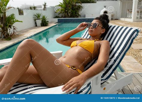 Woman In Bikini Relaxing On A Sun Lounger Near Swimming Pool Stock