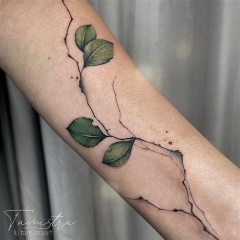 A Woman S Arm With A Vine And Leaves Tattoo On The Left Side Of Her Arm