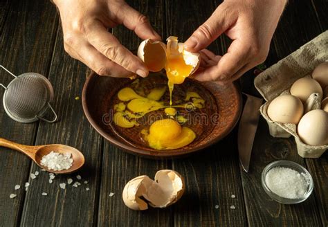 The Cook Prepares Eggs On The Kitchen Table For An Omelette The Chef S Hands Are Holding A