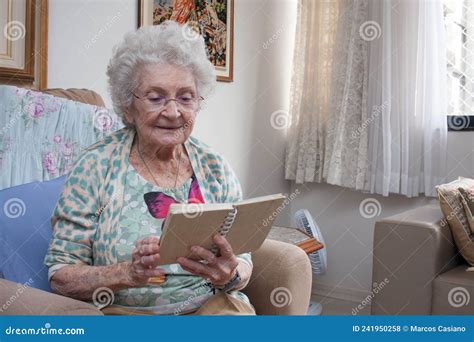 Senhora Idosa Em Casa Lendo Um Livro Foto De Stock Imagem De Relaxe