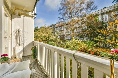 Premium Photo | A balcony with a white railing and plants and trees