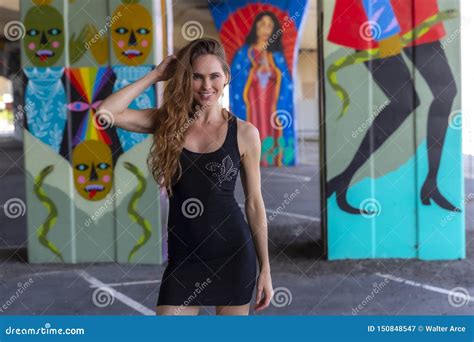 Lovely Brunette Model Posing Outdoors Against Graffiti Editorial