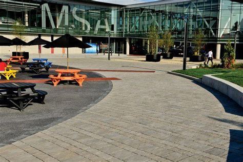 There Are Many Tables And Umbrellas In This Courtyard Area Outside The