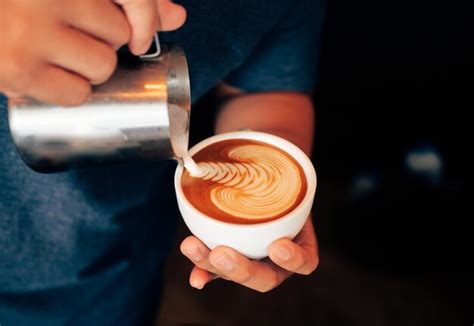 Premium Photo Midsection Of Barista Pouring Milk In Coffee Cup At Cafe